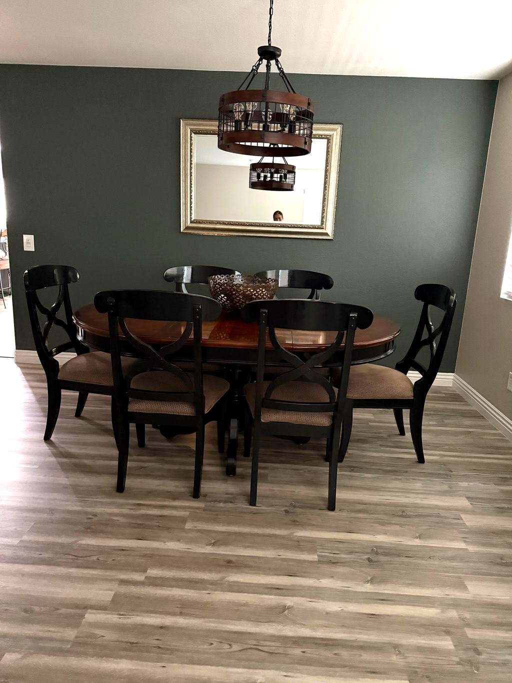 Tidy dining room with round wood table and a framed mirror