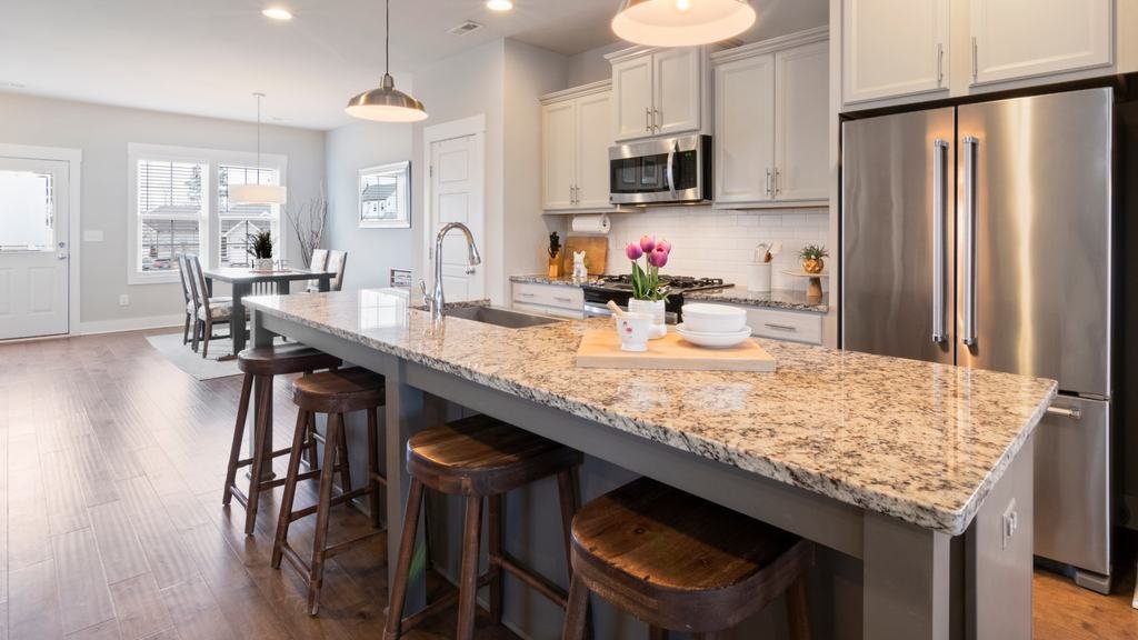 Clean kitchen with granite island and stainless appliances